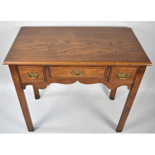 31 - A Mid 20th Century Oak Lowboy Table on Chamfered Rectangular Supports having Centre Drawer Flanked b... 