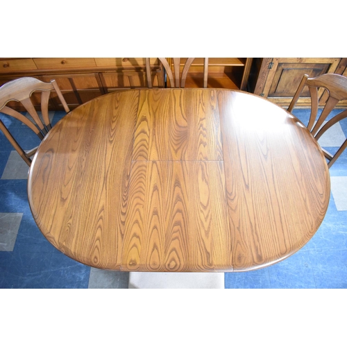 581 - An Extending Cousins and Matthews Oval Dining Table and Four Chairs