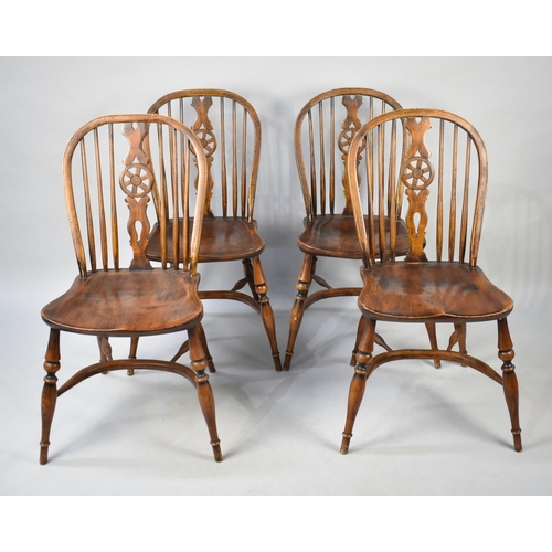 446 - A Set of Four Elm Seated Wheel Back Kitchen Chairs with Crinoline Stretchers