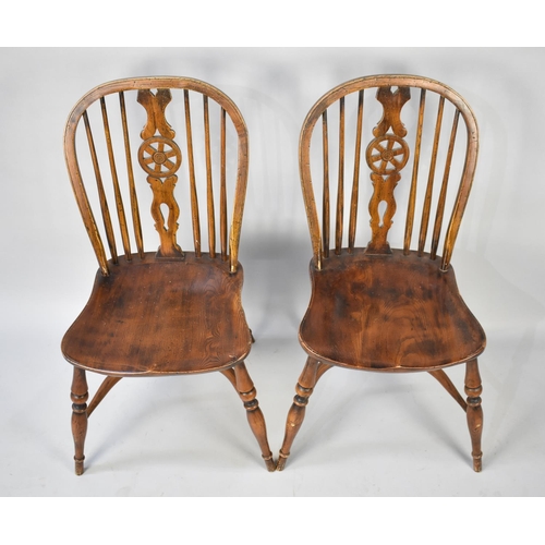 446 - A Set of Four Elm Seated Wheel Back Kitchen Chairs with Crinoline Stretchers