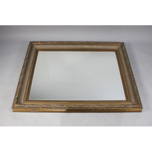 565 - A Large Gilt Framed Wall Mirror with Bevelled Glass, 127x103cms