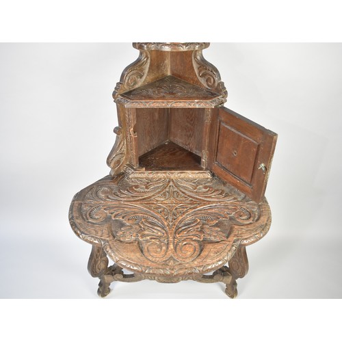 101 - A Late 19th Century Carved Oak Corner Table with Single Front Drop Leaf Raised Cupboard with Mask Ca... 