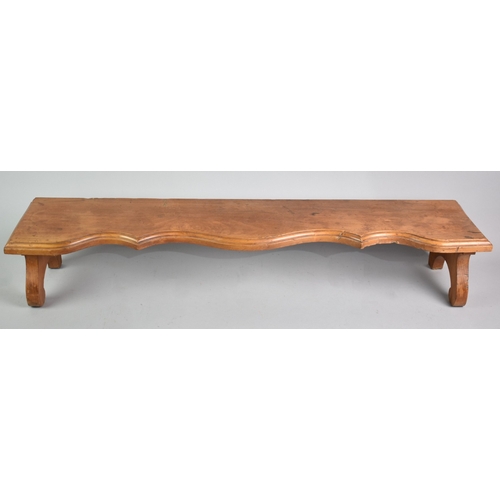 62 - A Wooden Serpentine Fronted Low Stand, 85cms Long and 15cms High