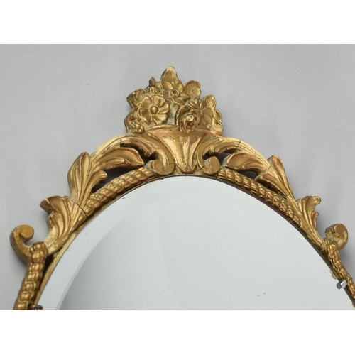 243 - An Oval Gilt Framed Wall Mirror, 74x40cs Overall