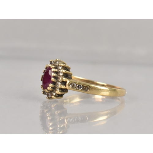 402 - A 9ct Gold, Ruby and CZ Cluster Ring, Oval Cut Ruby Approx 5.4mm by 3.9mm Supported in Fourteen Yell... 