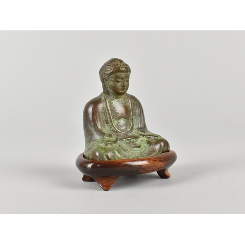 21 - A Green Patinated Bronze Miniature Buddha on Wooden Stand, Late 20th Century, 8cms High
