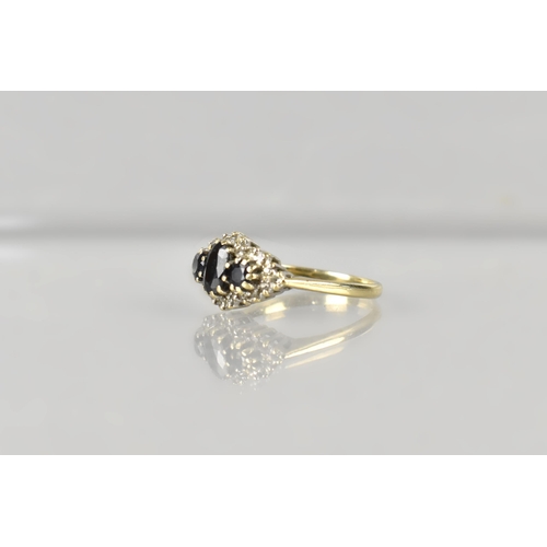 17 - A 9ct Gold, Sapphire and Diamond Cluster Ring, Primary Oval Cut Sapphire Measuring 5.2mm by 3.5mm, S... 