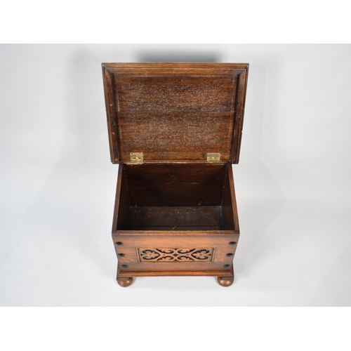59 - An Edwardian Oak Box with carved front panel and hinged lid, 51cm wide and 41cm high