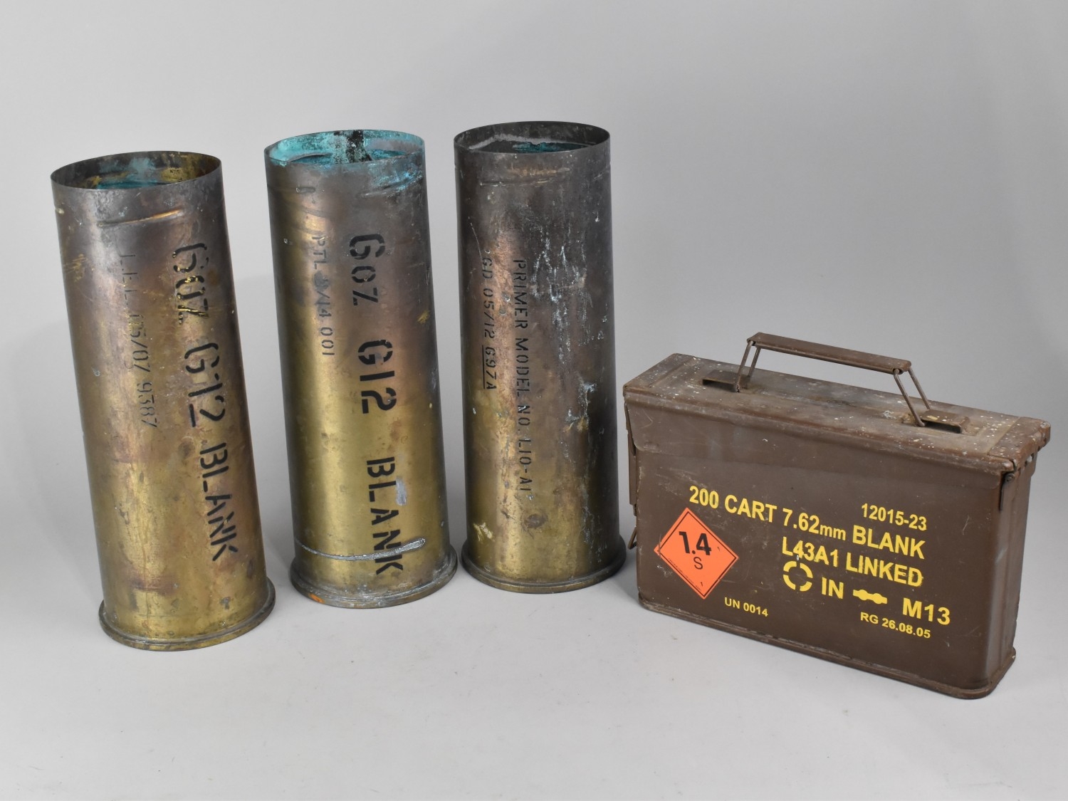 A Collection of Three Brass Blank Shell Bases and a Metal Ammunition ...