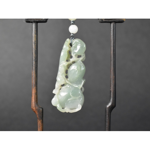 29 - A Chinese Jade Effect Pendant in Carved Wooden Arched Stand, 18.5cms High