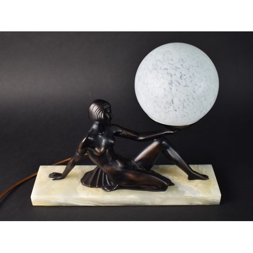 55 - A Reproduction Bronze Effect Art Deco Style Table Lamp in the Form of a Reclining Nude Supporting Gl... 