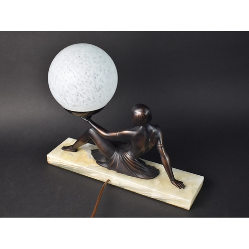 55 - A Reproduction Bronze Effect Art Deco Style Table Lamp in the Form of a Reclining Nude Supporting Gl... 