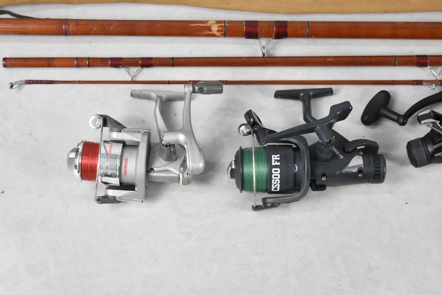 A Collection of Various Vintage Split Cane Fishing Rods Together with Reels