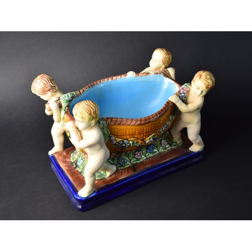 235 - A Reproduction Majolica Glazed Table Centre in the Form of Four Cherubs Carrying Basket, 29cms Long