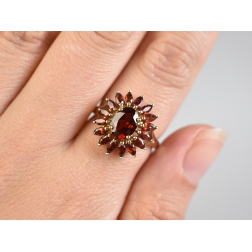 16 - A 9ct Gold and Garnet Set Dress Ring, Central Oval Cut Stone Measuring 7.7mm by 5.7mm Supported in F... 