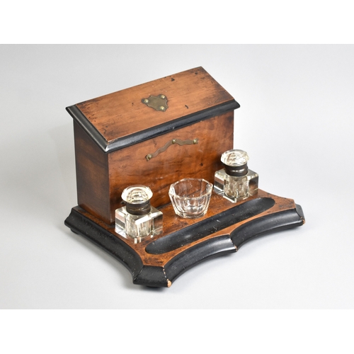 A Late Victorian Walnut Stationery Box and Ink Stand with Centre Small Bowl Flanked by Two Glass Inkwells, Raised Fitted Stationery Store with Sloping Lid, 28cms Wide