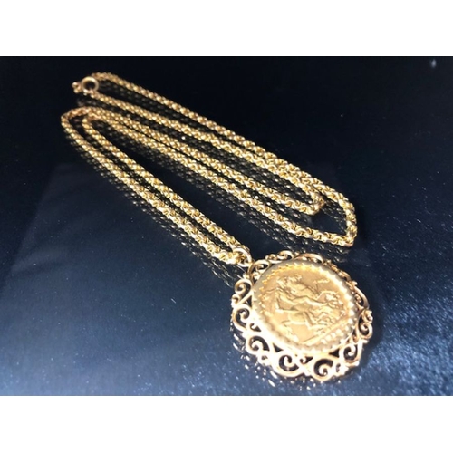 12 - A 1910 Full Gold sovereign in a pierced and scrolling style mount on a Long 9ct Gold chain (approx 7... 