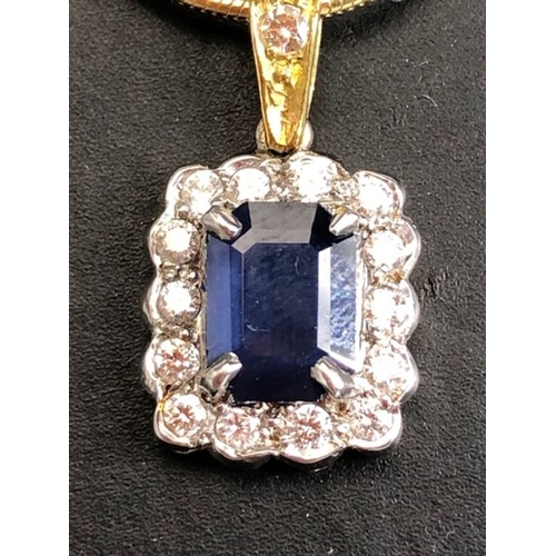 21 - 18ct sapphire and diamond pendant, cushion cut sapphire surrounded by diamonds on a rolled serpentin... 