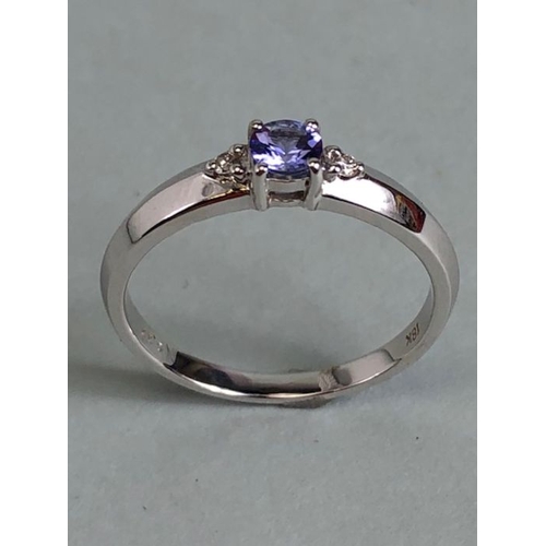 35 - 18k White gold ring set with Blue faceted Tanzanite stone and flanked by Diamond shoulders total wei... 