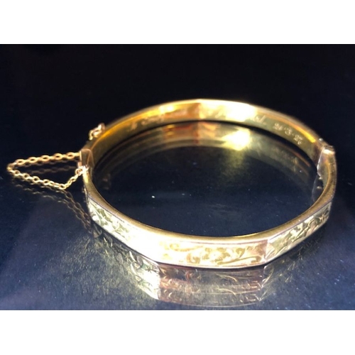 38 - 9ct fully hallmarked Gold bangle with floral engraving, good clasp and safety chain total weight app... 