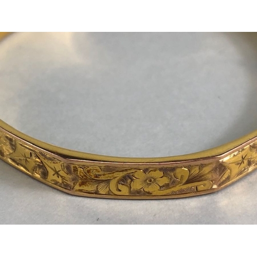 38 - 9ct fully hallmarked Gold bangle with floral engraving, good clasp and safety chain total weight app... 