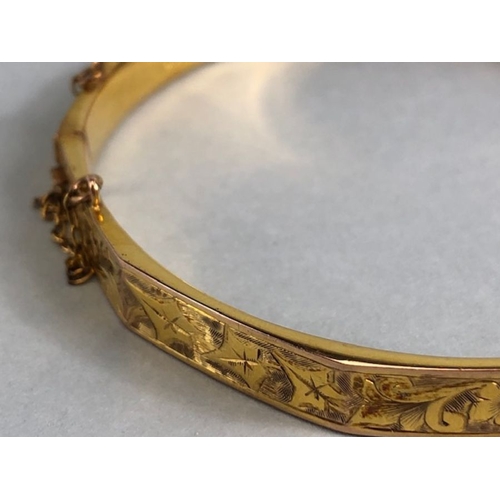 38 - 9ct fully hallmarked Gold bangle with floral engraving, good clasp and safety chain total weight app... 