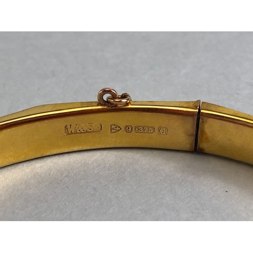 38 - 9ct fully hallmarked Gold bangle with floral engraving, good clasp and safety chain total weight app... 