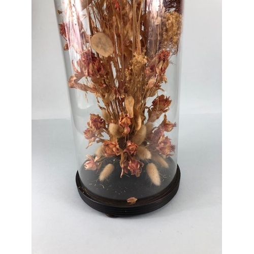 386 - Tall glass Victorian dome on ebonised wooden base, currently containing dried flowers, approx 60cm t... 