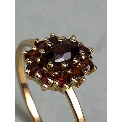 48 - 9ct Garnet cluster ring size 'P' with central oval stone surrounded by 10 smaller garnets size appro... 