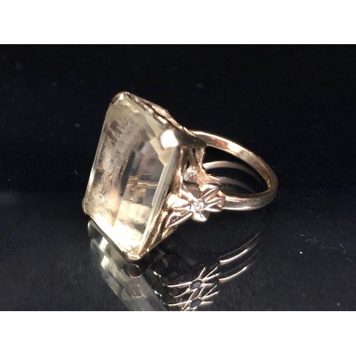 25A - 9ct yellow gold ring mounted with a pale quartz  Emerald cut stone the shoulders of butterfly design... 