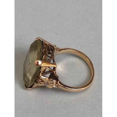 25A - 9ct yellow gold ring mounted with a pale quartz  Emerald cut stone the shoulders of butterfly design... 