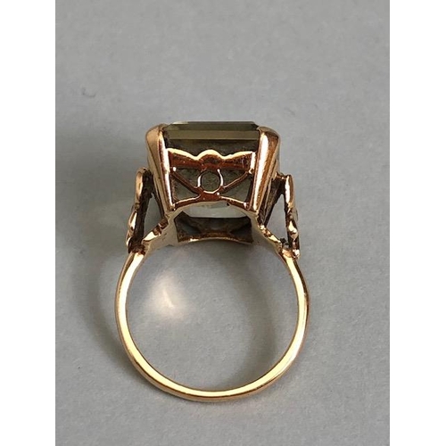 25A - 9ct yellow gold ring mounted with a pale quartz  Emerald cut stone the shoulders of butterfly design... 