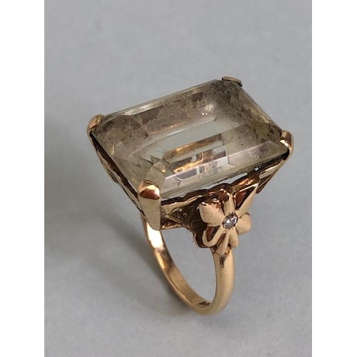 25A - 9ct yellow gold ring mounted with a pale quartz  Emerald cut stone the shoulders of butterfly design... 