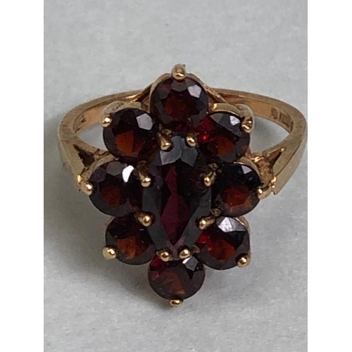 60 - 9ct gold daisy style ring set with nine garnets in claw settings with large oval central garnet on r... 