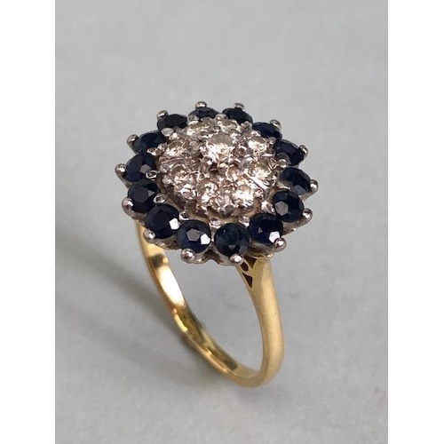 64a - 18ct yellow gold Diamond and Sapphire Daisy style ring. A central diamond surrounded by a ring of ei... 