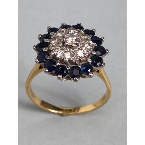 64a - 18ct yellow gold Diamond and Sapphire Daisy style ring. A central diamond surrounded by a ring of ei... 