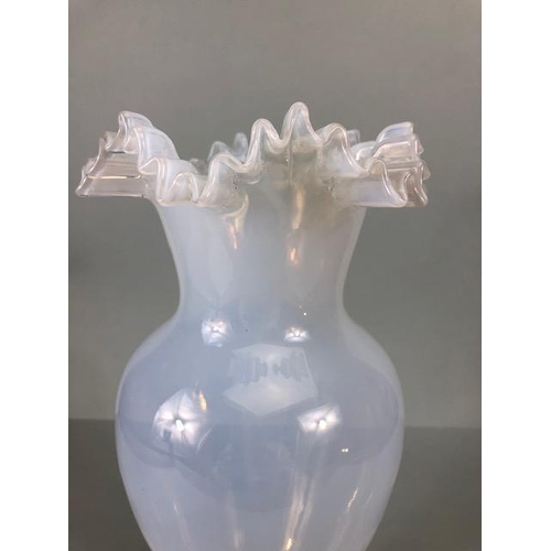 121 - Art Glass: A Vaseline Translucent Blue glass vase on a stepped circular base with a wavey rim approx... 