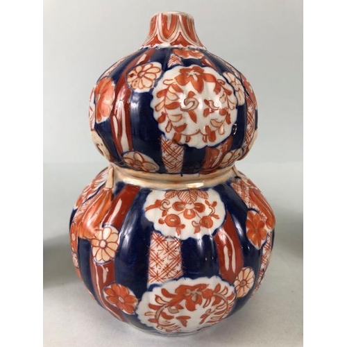 135 - Oriental ceramics, a pair of Japanese Imari vases decorated in blue and red with flowers, un-marked ... 