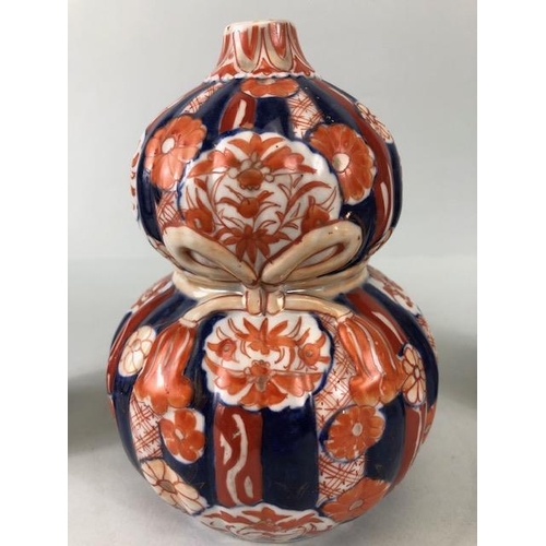 135 - Oriental ceramics, a pair of Japanese Imari vases decorated in blue and red with flowers, un-marked ... 