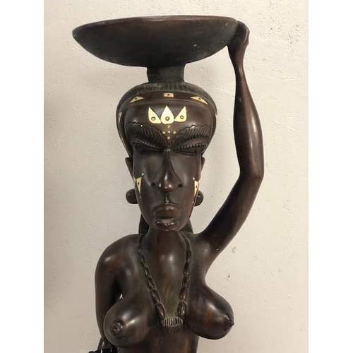 139 - African Sculpture, a large carved wooden statue of a Kneeling woman wearing beads and carrying a bas... 