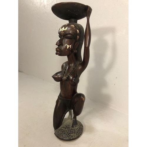 139 - African Sculpture, a large carved wooden statue of a Kneeling woman wearing beads and carrying a bas... 