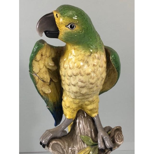 216 - 18th century style Majolica green parrot perched on a tree stump, old stapled repair to wing approxi... 