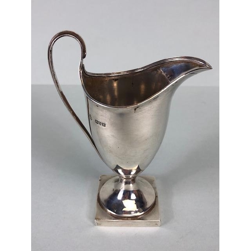 42 - Silver Hallmarked jug on square base looping handle and fluted spout and rim, hallmarked for Chester... 