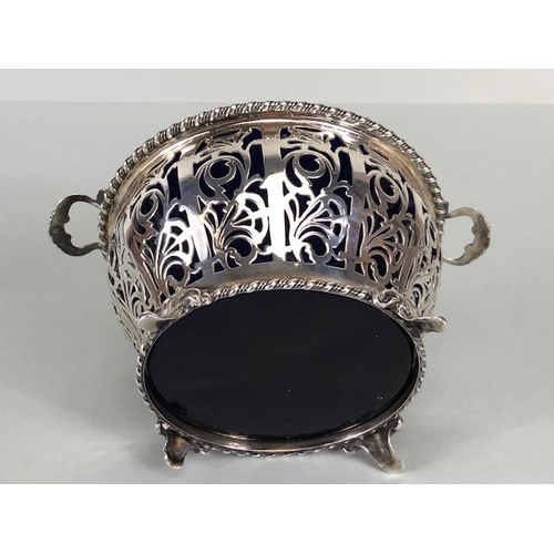 7 - Silver hallmarked open work or pierced design basket with twin handles on four splayed feet containi... 