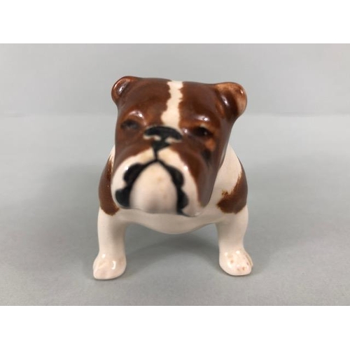 127 - Ceramic Bulldogs, four bulldog figures of varying size, one with Coppercraft trade label to base, on... 