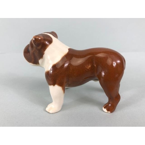 127 - Ceramic Bulldogs, four bulldog figures of varying size, one with Coppercraft trade label to base, on... 