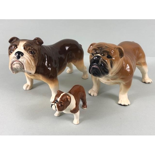 127 - Ceramic Bulldogs, four bulldog figures of varying size, one with Coppercraft trade label to base, on... 