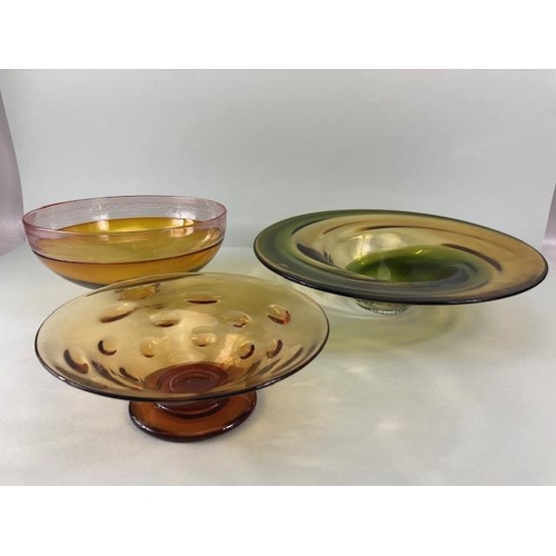 245 - Art Studio glass, Three amber glass bowls all with ground bases one with a signature