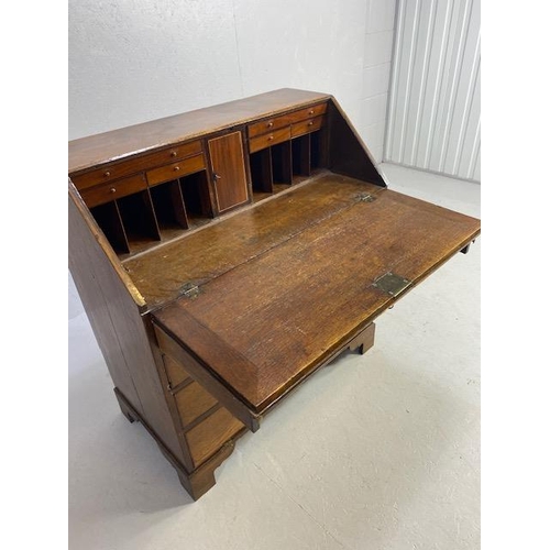 316 - Oak Bureau with four drawers, fall front revealing pigeon holes and ornate key to lock