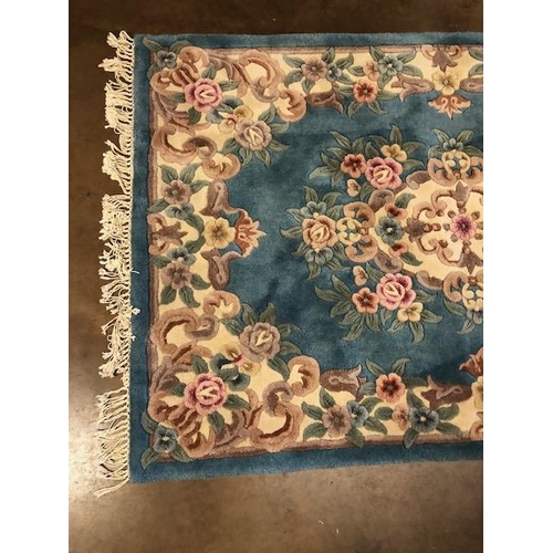 359 - Chinese wool rug of sculpted style with typical designs of flowers and  against a blue grey  back gr... 